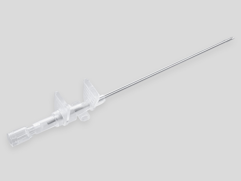 Braunula Vet High Flow Intravenenkatheter mit langer Metallkanüle und transparentem Kunststoffansatz mit seitlichen Fixierflügeln, freigestellt auf hellgrauem Hintergrund.