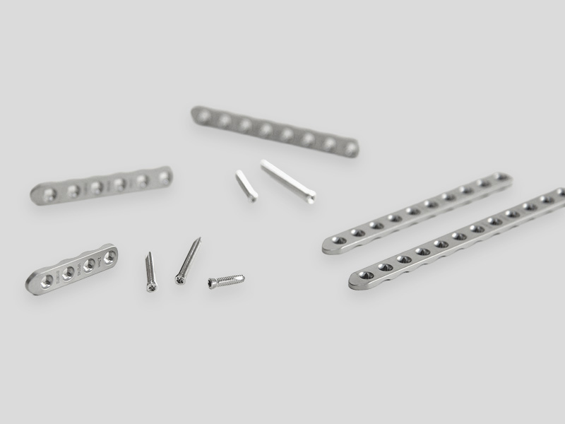 PLS2 orthopädische Fixationsplatten und Schrauben in verschiedenen Größen, auf hellem Hintergrund angeordnet.